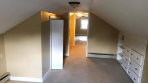 Carpeted attic flex room with built in drawers and small closet