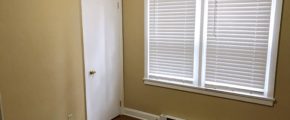 Bedroom with closet, window, and laminate, hardwood-style flooring