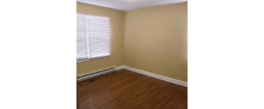 Bedroom with window and laminate, hardwood-style flooring