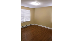 Bedroom with window and laminate, hardwood-style flooring