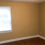 Bedroom with closet, window, and laminate, hardwood-style flooring