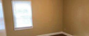 Bedroom with closet, window, and laminate, hardwood-style flooring