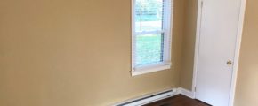 Bedroom with closet, window, and laminate, hardwood-style flooring