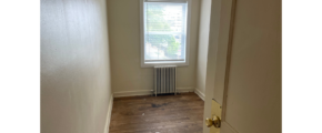an empty room with a radiator and a window