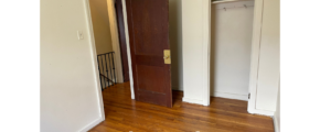 an empty room with a door and a closet