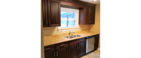 Kitchen with tile floor, dishwasher, double sink and cabinets