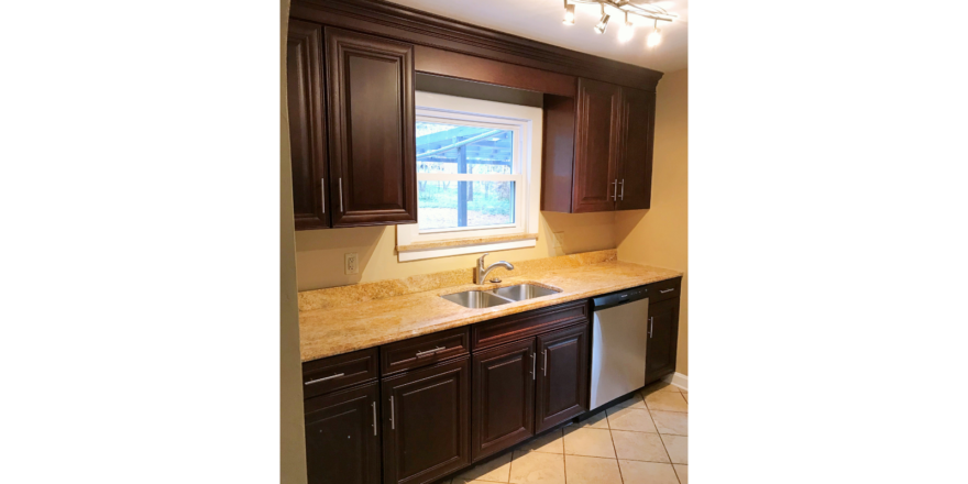 Kitchen with tile floor, dishwasher, double sink and cabinets