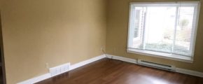 Living room with laminate, hardwood-style form and large picture window