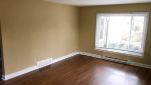 Living room with laminate, hardwood-style form and large picture window