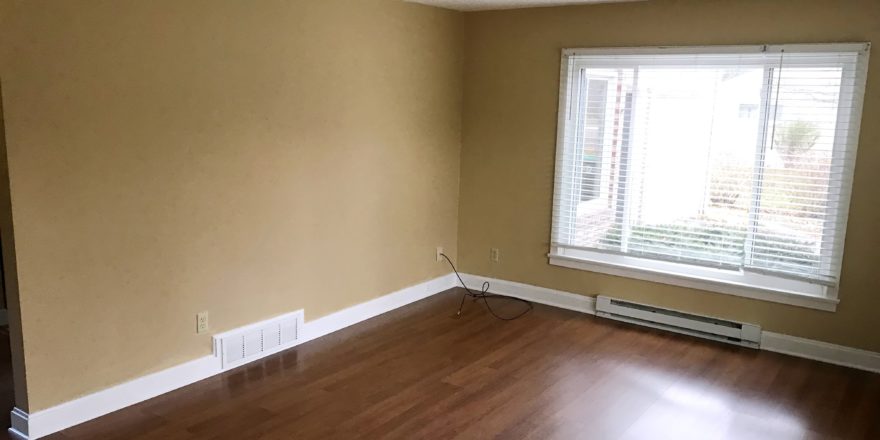 Living room with laminate, hardwood-style form and large picture window