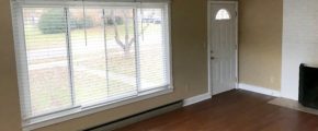 Living room with laminate, hardwood-style form, large picture window and fire place