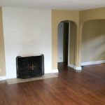 Living room with laminate, hardwood-style floors and fire place with front cover