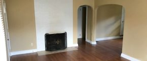 Living room with laminate, hardwood-style floors and fire place with front cover