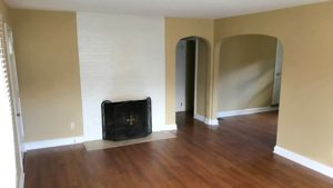 Living room with laminate, hardwood-style floors and fire place with front cover