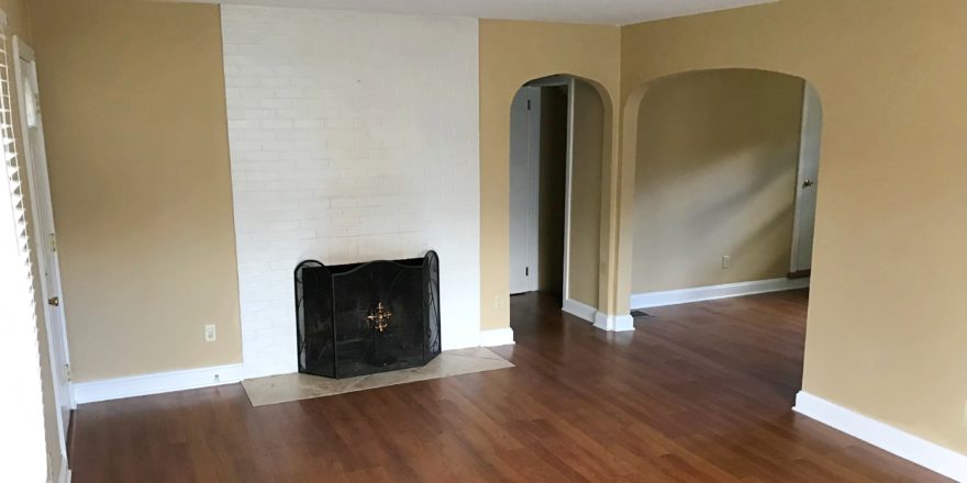 Living room with laminate, hardwood-style floors and fire place with front cover