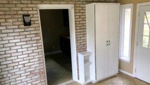 Tiled mudroom with storage cabinet