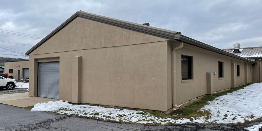 a tan building with two garages on the side of it