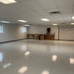 an empty room with white walls and floors