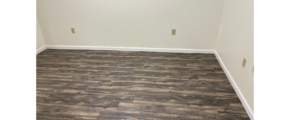 an empty room with a wood floor and white walls