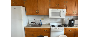 a kitchen with a table, refrigerator and microwave
