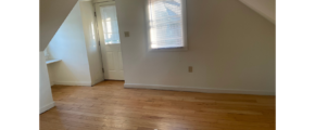 an empty room with a white door and window