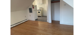 an empty room with wood floors and a white wall