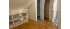 an empty room with a book shelf and a closet