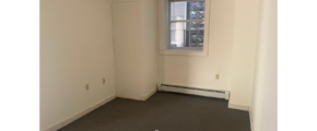 an empty room with a window and a radiator
