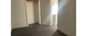 an empty room with a door and a window