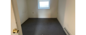 an empty room with a window and a radiator