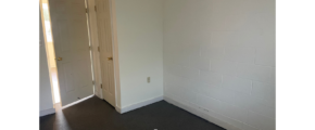an empty room with a door and a mirror