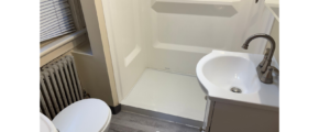 a bathroom with a toilet, sink, and shower