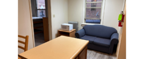 a living room with a couch a chair and a desk