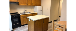 a kitchen with a table and a refrigerator