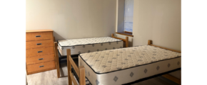 a bedroom with two beds and a dresser