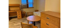 a room with a desk, chair, and bed in it