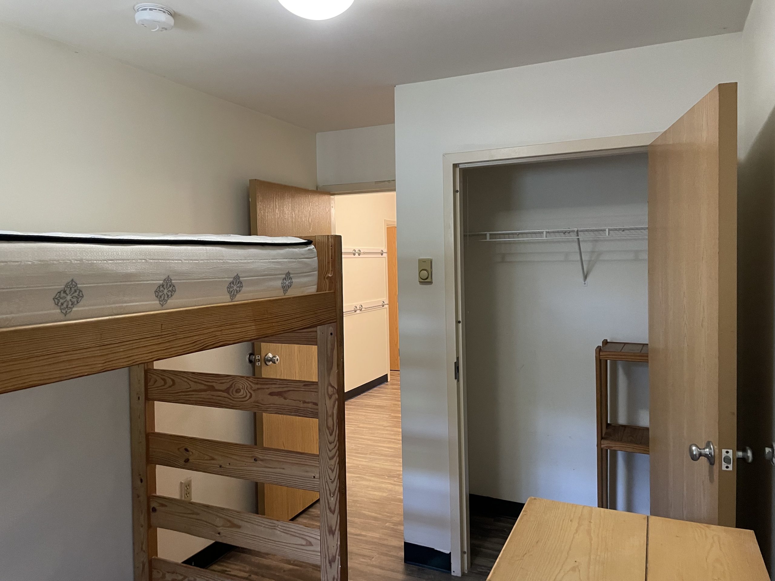Dorm room with bunk bed and closet