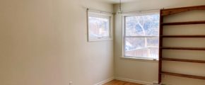 Unfurnished bedroom with wood floors, ceiling fan, and wall-mounted bookshelf