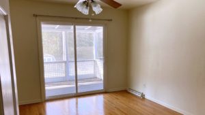 Unfurnished bedroom with wood floors, ceiling fan, and sliding glass door onto balcony