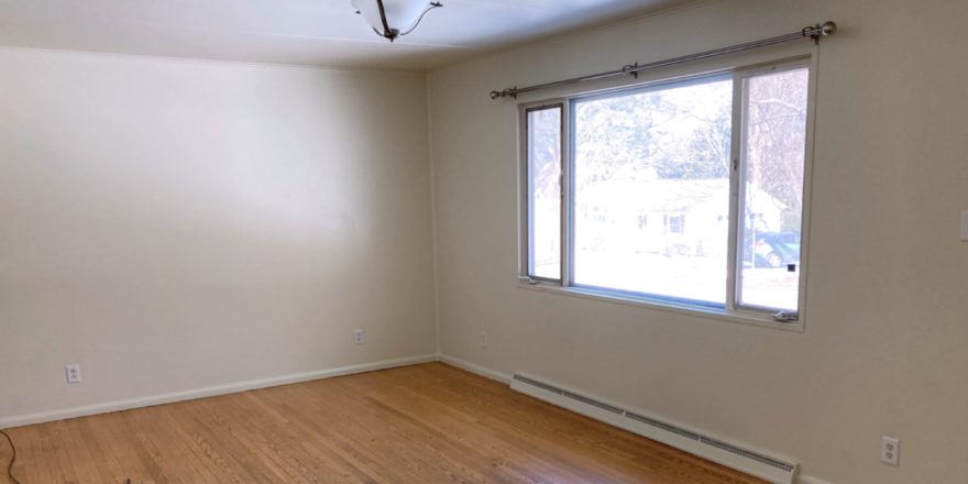 Unfurnished living room with wood floors and ceiling lighting fixture