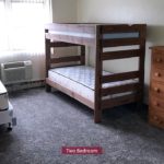 Carpeted Bedroom with bunk bed and twin bed, and wood chests of drawers