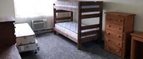 Carpeted Bedroom with bunk bed and twin bed, and wood chests of drawers