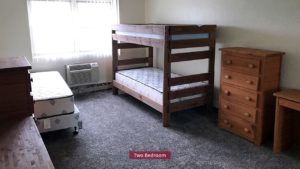 Carpeted Bedroom with bunk bed and twin bed, and wood chests of drawers