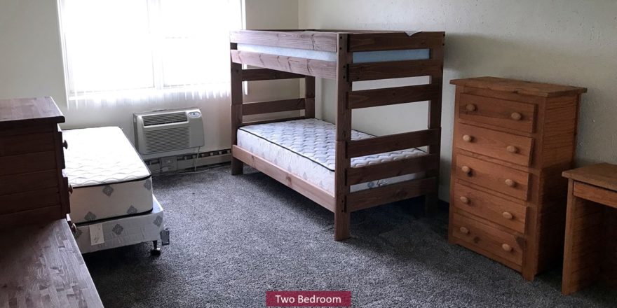 Carpeted Bedroom with bunk bed and twin bed, and wood chests of drawers