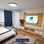 a bed room with a neatly made bed and a flat screen tv
