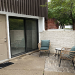 two chairs sitting on a patio next to a door