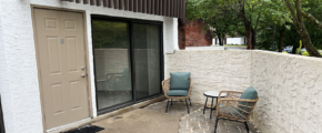 two chairs sitting on a patio next to a door