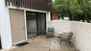 two chairs sitting on a patio next to a door