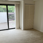 an empty room with sliding glass doors leading to a balcony