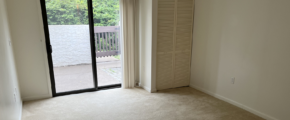 an empty room with sliding glass doors leading to a balcony